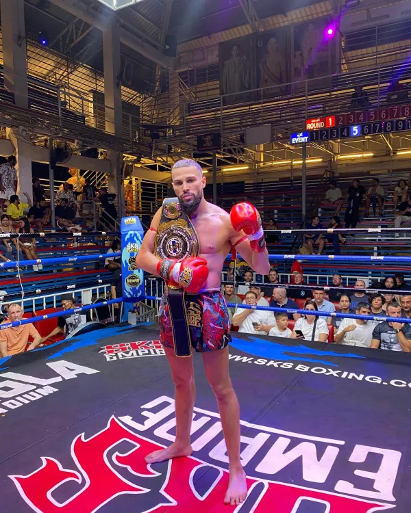 Amine, ceinture sur l'épaule, au centre du ring du Bangla Boxing Stadium devant le public